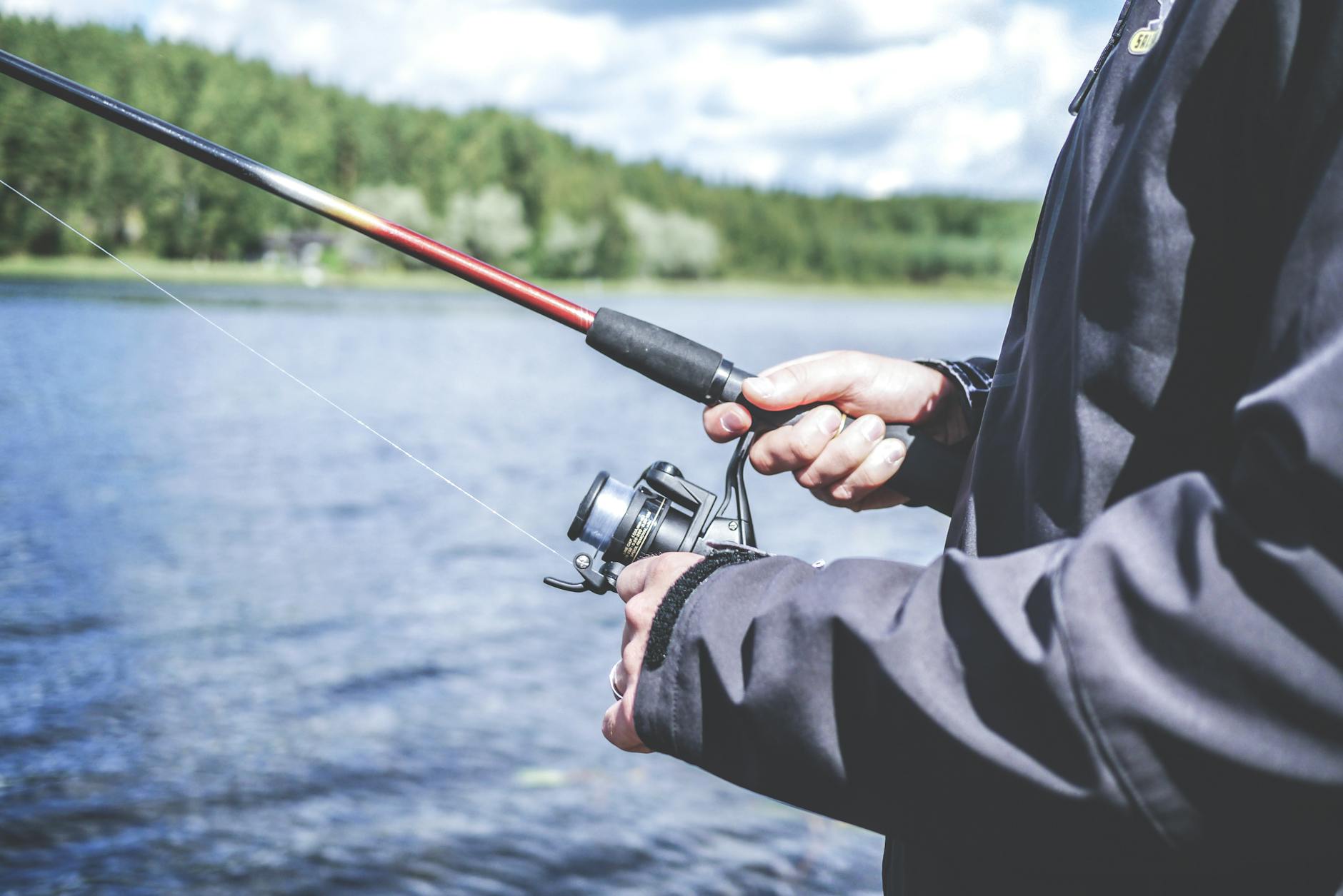 Un homme aime pêcher dans un lac, présentant un passe-temps extérieur détendu dans la nature.